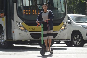 A atuária Samara Alce se locomove de patinete elétrico no centro do Rio de Janeiro.